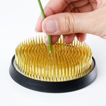 Load image into Gallery viewer, hand sticking a stem on the dense kenzan