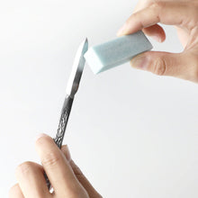 Load image into Gallery viewer, hand using fine grade sape eraser on chisel blade