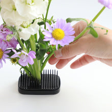Load image into Gallery viewer, hand stinging flower stem on the blakc kenzan
